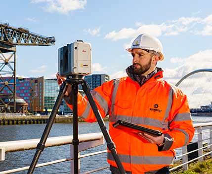Engineer Setting Up A Survey Laser Scanner On Civil Engineering Project